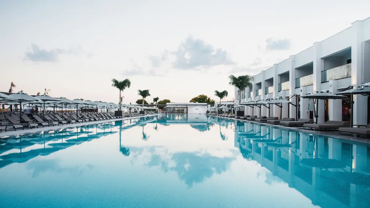 Paloma Finesse Side havuz, swim-up odalar, palmiyeler ve hafif bulutlu hava