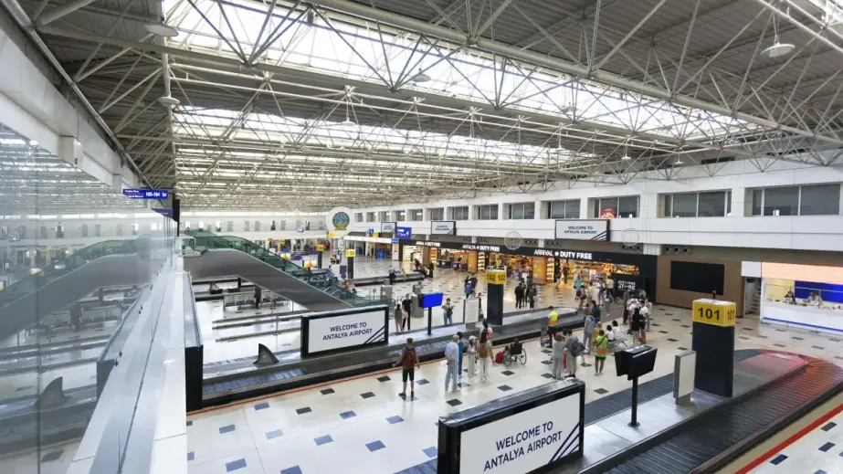 Passagiere im Terminal des Flughafens Antalya beim Gepäckbereich nahe dem Duty-free-Bereich