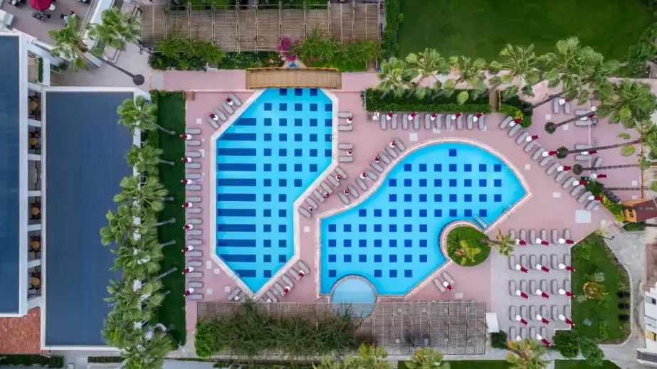 Trendy Palm Beach Drohnenansicht mit zwei Pools, Sonnenliegen, Palmen und Poolbar