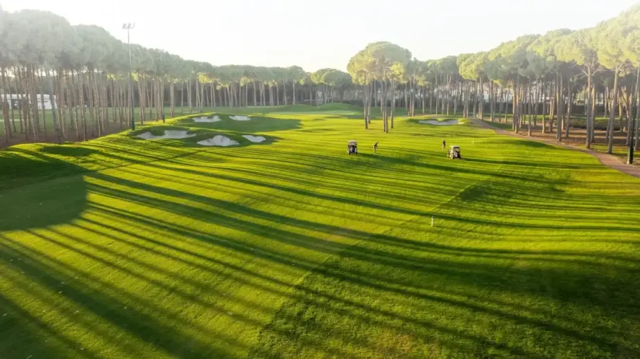 Golfspieler und Buggys auf dem Regnum Carya Golfplatz in Belek