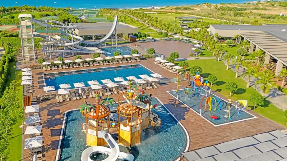 Kinderbecken und Wasserrutschen im Aquapark des Jacaranda Luxury Resort, dahinter Grün und Meer