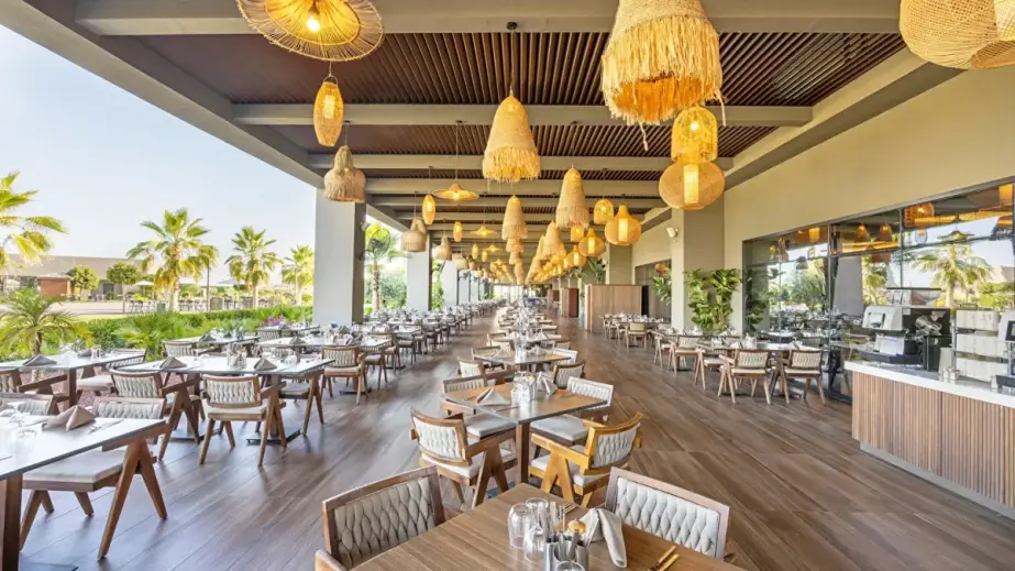 Restaurantbereich mit Tischen und Stühlen im Jacaranda Luxury Resort