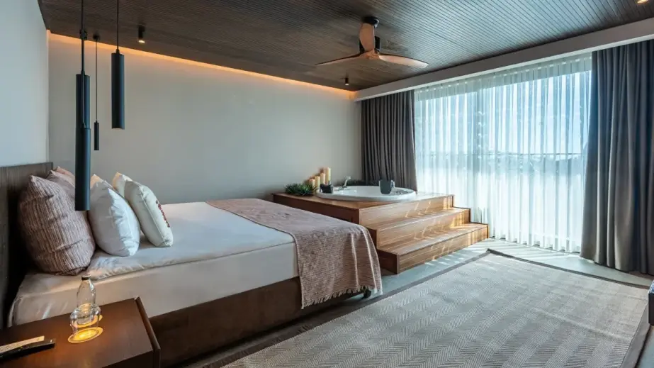 Zimmer im authentischen Stil mit Doppelbett und Whirlpool im Jacaranda Luxury Resort