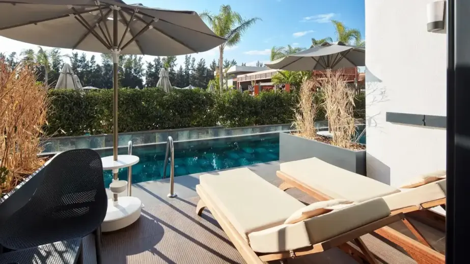 Terrasse eines Swim-up-Zimmers im Liu Resorts Hotel mit direktem Poolzugang und Palmen.