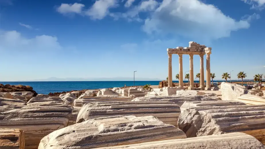 Säulen des Apollon-Tempels am Meer in der antiken Stadt Side, umgeben von Palmen